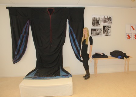 A TRC volunteer standing next to the Jordanian Thob 'Ubb, the largest dress in the world, on display in the TRC Gallery.